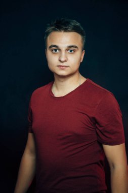 Karanlık bir arka planda genç bir adamın portresi.