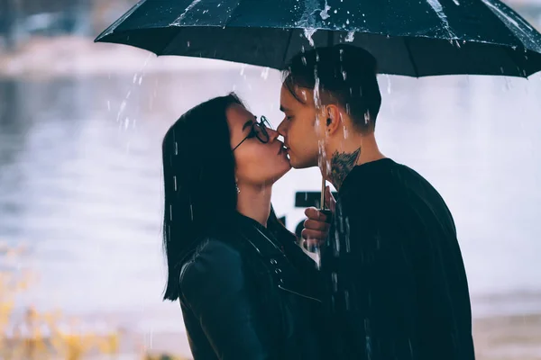 年轻的男人和女人下的伞和雨 — 图库照片