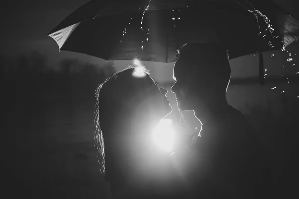 年轻男男女女在雨伞下的黑色白色照片 — 图库照片