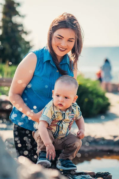 噴水の近くの幸せな母親と幼児の息子 — ストック写真