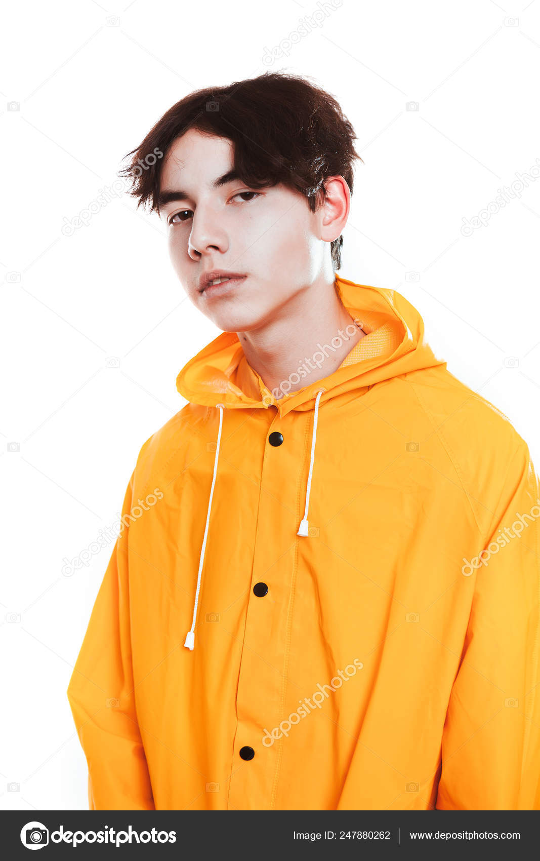 Retrato de un chico adolescente en una morena de impermeable amarillo en el estudio — Foto