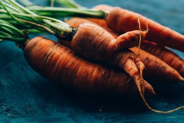 Mavi ahşap arka planda taze havuç.