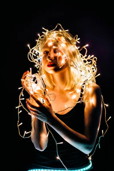 Blond meisje met elektrische bloemenslinger op haar hoofd — Stockfoto