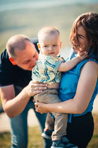 Familia feliz con bebé hijo en el fondo de la naturaleza — Foto de Stock