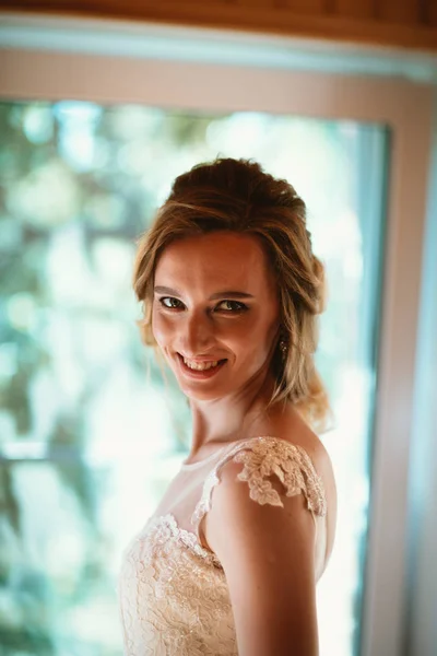Mooie jonge bruid op wazig kleur achtergrond — Stockfoto