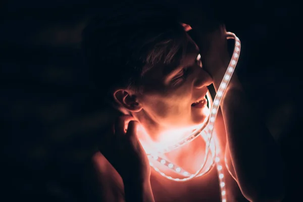 Retrato homem tira fita de luz no fundo de cor escura — Fotografia de Stock