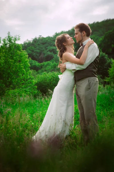 Mariée et marié se tiennent sur le fond de la montagne et de l'herbe — Photo