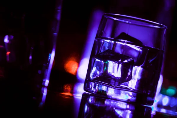 Färgad belysning av glasögon i nattklubbens bar — Stockfoto