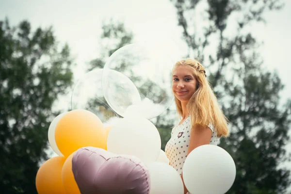 Giovane ragazza con palloncini su sfondo natura — Foto Stock
