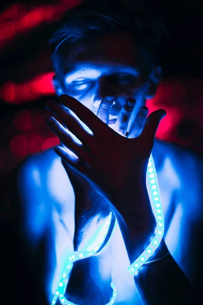 Retrato homem tira fita de luz no fundo de cor escura — Fotografia de Stock