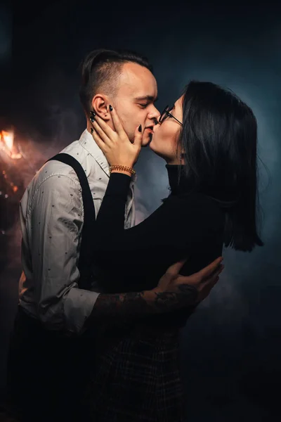 Пара в модной одежде на темном фоне с дымом — стоковое фото