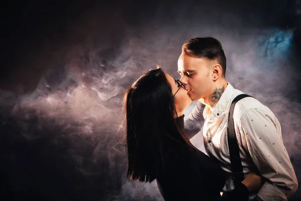 Pasangan dalam pakaian modis pada latar belakang asap gelap — Stok Foto