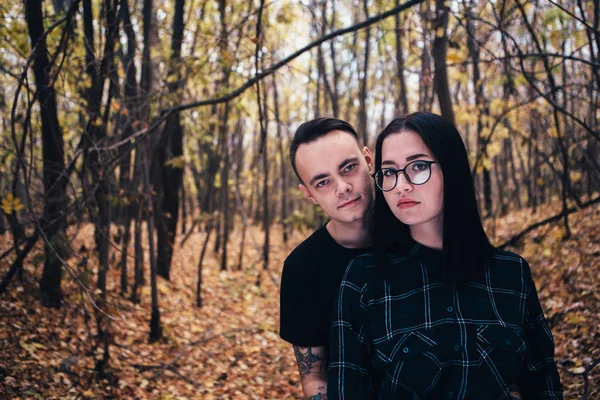 Young man and woman in the autumn forest — Stock Photo, Image