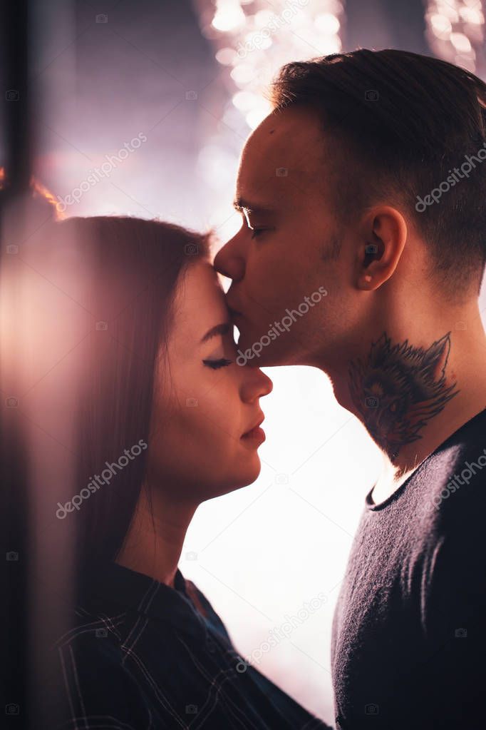 guy and the girl kiss closeup on a light background.