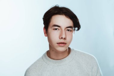 Stüdyo portre genç adam beyaz arka planda gri süveterli