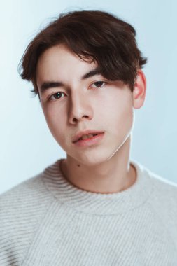 Stüdyo portre genç adam beyaz arka planda gri süveterli