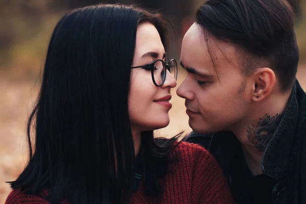 Ein junger Mann und eine junge Frau sitzen auf einem Karo in einem Herbstkleid. — Stockfoto