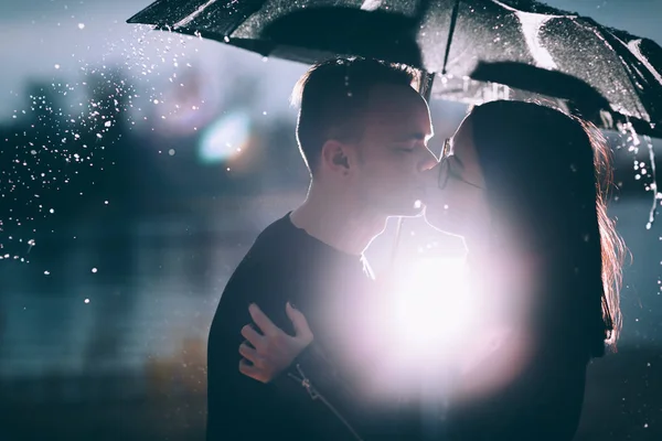 Jeune couple debout sous un parapluie sombre — Photo