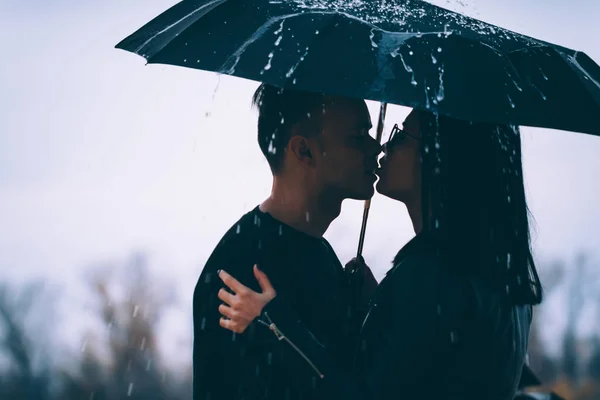 Jeune couple debout sous un parapluie sombre — Photo