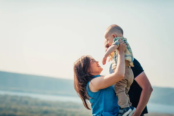 赤ちゃんの息子と幸せな家族自然を背景に — ストック写真