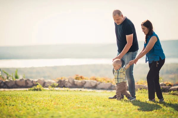 Gelukkig gezin met baby op groen gras — Stockfoto