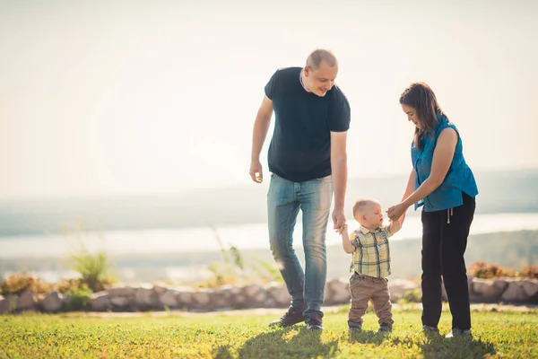 Gelukkig gezin met baby op groen gras — Stockfoto