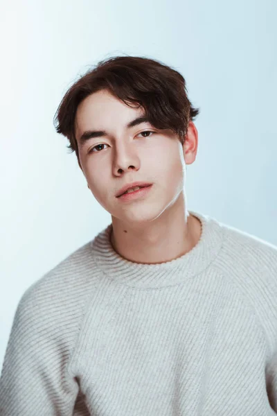 Estúdio retrato jovem em camisola cinza no fundo branco — Fotografia de Stock