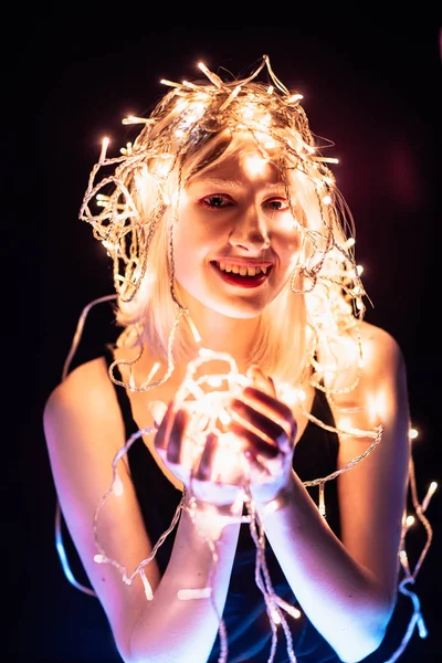 Portrait of a girl with a garland on black background — Stock Photo, Image