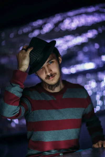 Portrait of a guy in a hat on a blurred background — Stock Photo, Image
