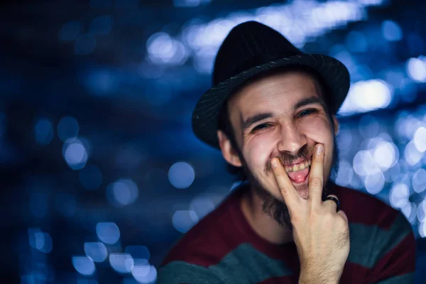 Retrato de um cara em um chapéu em um fundo borrado — Fotografia de Stock