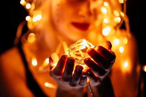 Retrato de una chica con una guirnalda sobre fondo negro — Foto de Stock