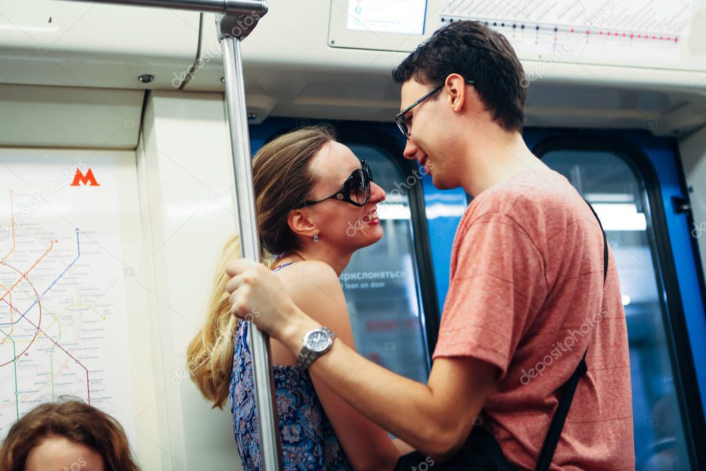 girl and guy stand in the subway