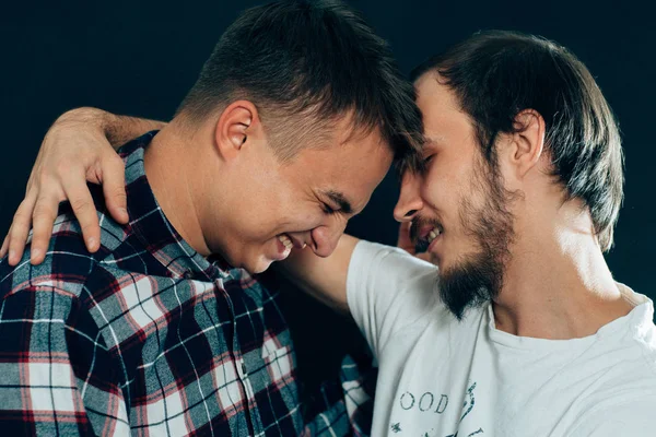 Dos chicos abrazándose sobre un fondo oscuro —  Fotos de Stock