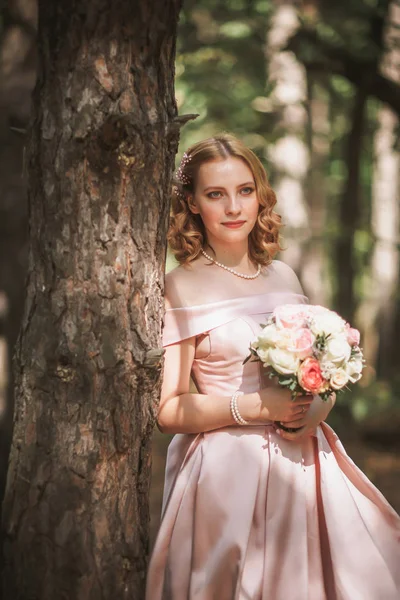 Retrato de uma bela noiva em pé perto de uma árvore — Fotografia de Stock