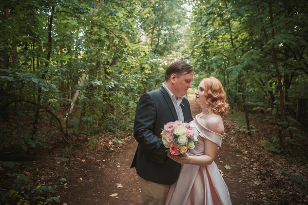 Brud och brudgum dansar i skogen bakgrunden och solljus — Stockfoto