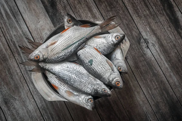 Fresh fish on the table in an iron bowl. — Stock Photo, Image