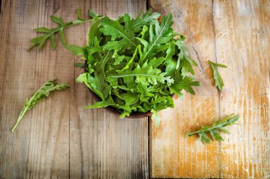 Masada taze yeşil roka yaprakları var. Yakın planda sunuldu.