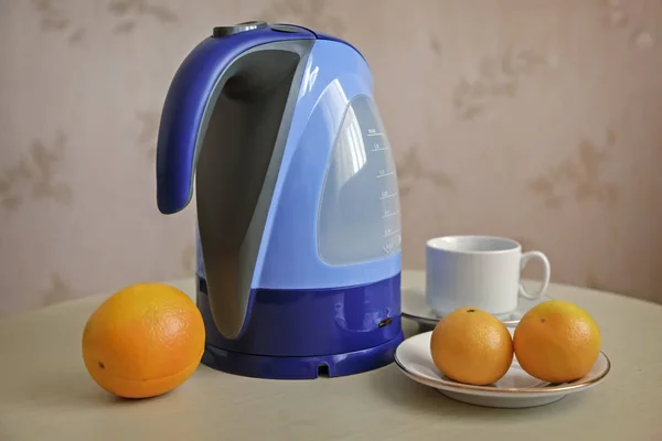 Auf Dem Tisch Steht Ein Wasserkocher Daneben Orangen Und Mandarinen — Stockfoto