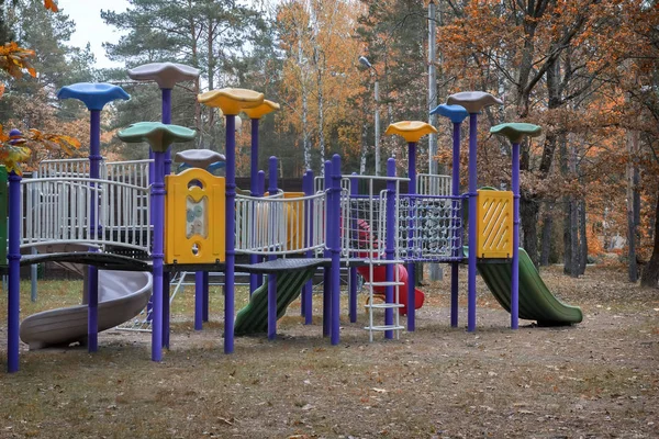 Um parque infantil para crianças no outono Park . — Fotografia de Stock