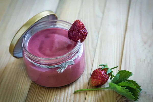 Üzerinde tablo çilek güler yüzlü bir kapaklı bir kavanoz içinde bir cam tabak.