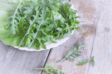 Masada taze yeşil roka yaprakları var. Yakın planda sunuldu.