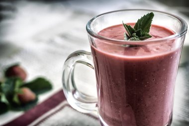 Bir peçete çilek yüzlü nane yaprakları ile masaya bir cam tabak içinde. Sunulan yakın çekim.