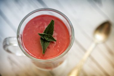 Bir peçete çilek yüzlü nane yaprakları ile masaya bir cam tabak içinde. Sunulan yakın çekim.