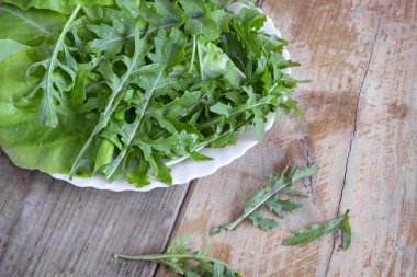 Masada taze yeşil roka yaprakları var. Yakın planda sunuldu.