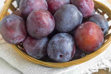 Hasır sepette olgun erikler.