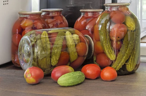 Tomates et concombres en conserve dans de grands pots en verre. — Photo