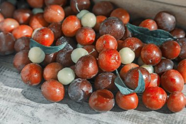 Masanın üzerinde kırmızı ve sarı olgun erik.