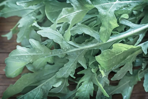 Foglie verdi fresche di rucola sul tavolo — Foto Stock