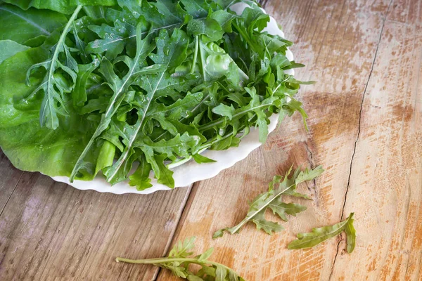 Folhas verdes frescas de arugula na mesa — Fotografia de Stock