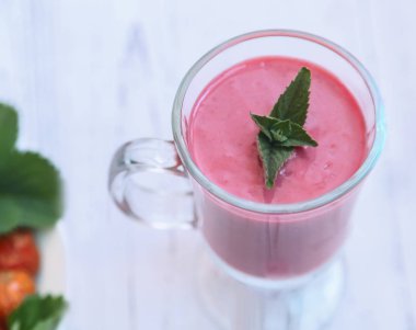 Bir peçete çilek yüzlü nane yaprakları ile masaya bir cam tabak içinde. Sunulan yakın çekim.